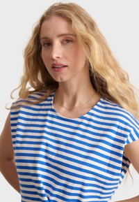 Vit och blårandig t-shirt i bomull, med rund halsringning och korta ärmar. Slät textur med en avslappnad passform.