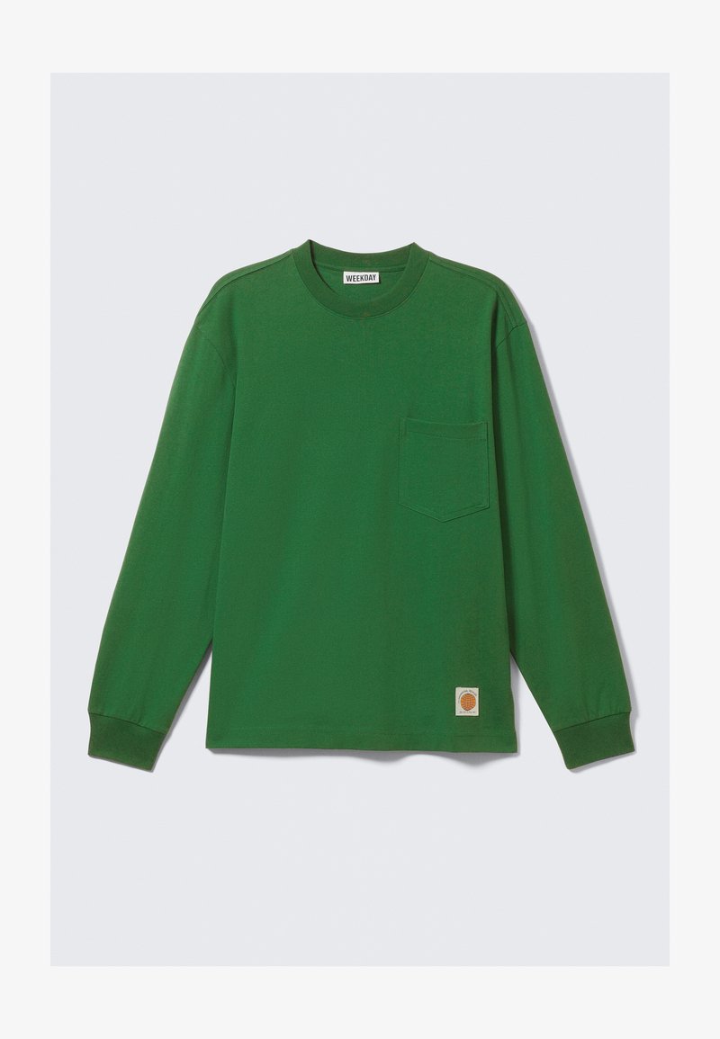 Long-sleeve, green cotton shirt with a crew neck, single chest pocket, and a small logo patch at the hem. Smooth texture, relaxed fit.