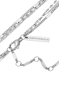 Collana multi-catena in argento con chiusura a moschettone e un'etichetta rettangolare incisa con "LIEBESKINDBERLIN."