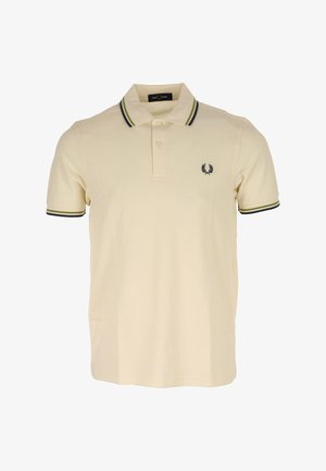 Beige poloshirt gemaakt van katoen, met een klassieke kraag, drie knopen en een logo op de linkerkant van de borst, voorzien van donkergroene en zwarte gestreepte accenten op de mouwen.