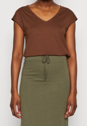 Camiseta marrón de cuello en V con mangas cortas, combinada con una falda verde con cordón. Ambas prendas cuentan con una tela suave y elástica.