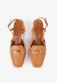 Brązowe skórzane buty slingback z kwadratowym noskiem, złotymi akcentami i fakturowaną powierzchnią. Posiadają regulowane paski wokół kostki.