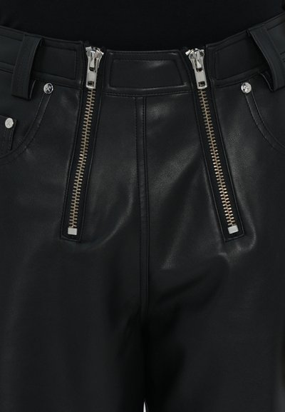 Schwarze Lederhosen mit hoher Taille, ausgestattet mit zwei silbernen Reißverschlussarten und Seitentaschen, mit glatter Textur und taillierten Details.