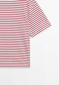T-shirt rayé rouge et blanc à manches courtes, fabriqué en tissu léger, avec des rayures horizontales régulièrement espacées et une coupe décontractée.