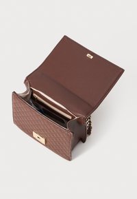 Bruine leren handtas met een gequiltde textuur, gouden hardware en een ritszakje aan de binnenkant, met een functionele klipsluiting.