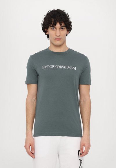 Šedé bavlněné tričko s krátkými rukávy a kulatým výstřihem, s bílým logem "Emporio Armani" na prsou.