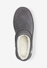 Pantofole grigio scuro con morbida fodera in pelliccia sintetica bianca, forma arrotondata, dettagli di cucitura sottili e materiale esterno testurizzato.