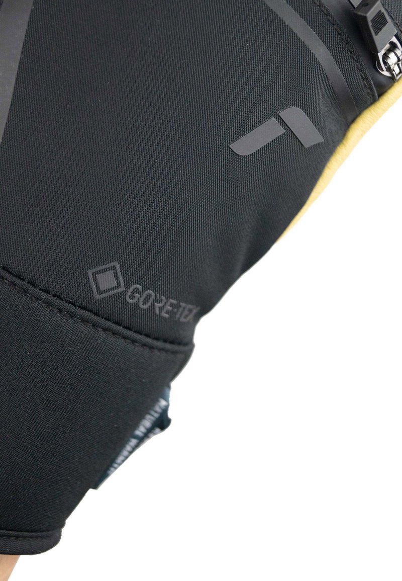 Svart GORE-TEX tyg med en strukturerad yta, med en dold dragkedja och tryckta logodetaljer, vilket framhäver en strömlinjeformad design.