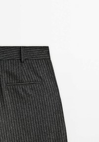 Pantalon gris foncé à fines rayures avec une poche passepoilée arrière et une boucle de ceinture sur fond blanc.