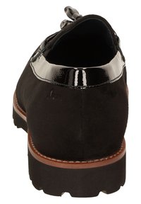 Schwarze Wildlederschuhe mit einem glänzenden schwarzen Lacklederbesatz um den Kragen, mit einem runden Absatz und braunen Lederdetails auf der Sohle.