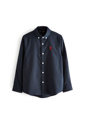 Chemise bleu foncé à manches longues avec boutons blancs et un petit emblème de homard rouge sur la poitrine gauche.