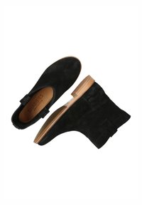 Black suede ankle boots with a low heel, featuring a smooth texture, elastic side panels, and a natural wood sole.
