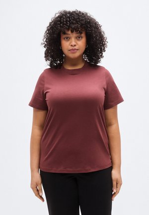 Bordeauxrotes T-Shirt mit kurzen Ärmeln aus weicher Baumwolle. Es verfügt über einen runden Ausschnitt und eine lockere Passform. Kombiniert mit schwarzen, einfarbigen Hosen ohne Muster.