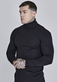 Schwarzes Langarm-Rollkragen-Shirt aus elastischem Stoff, tailliertes Design, das muskulöse Konturen betont, mit geschlossenen Bündchen und glatter Textur.