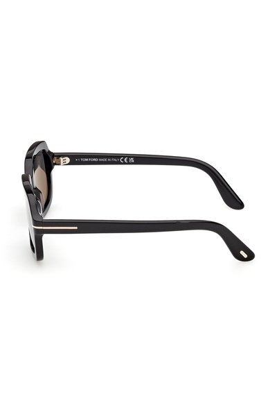 Lunettes de soleil Tom Ford noires avec des montures rectangulaires épaisses et des accents dorés sur les branches, vues de profil sur un fond blanc.