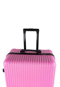 Maleta rígida rosa con ranuras verticales, cremallera y asa negras, y un asa retráctil negra en la parte superior.