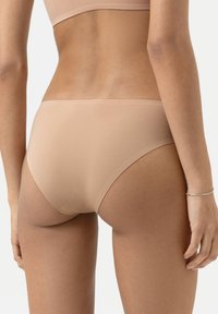 Beige nahtlose Unterwäsche mit glatter Textur, moderater Bedeckung und niedriger Taille, entworfen für Komfort und minimale Sichtbarkeit.