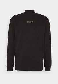 Zwarte lange mouwen turtleneck gemaakt van zachte stof, met een subtiele HUGO-logo in goud. Standaard pasvorm met geribde mouwen en hals.