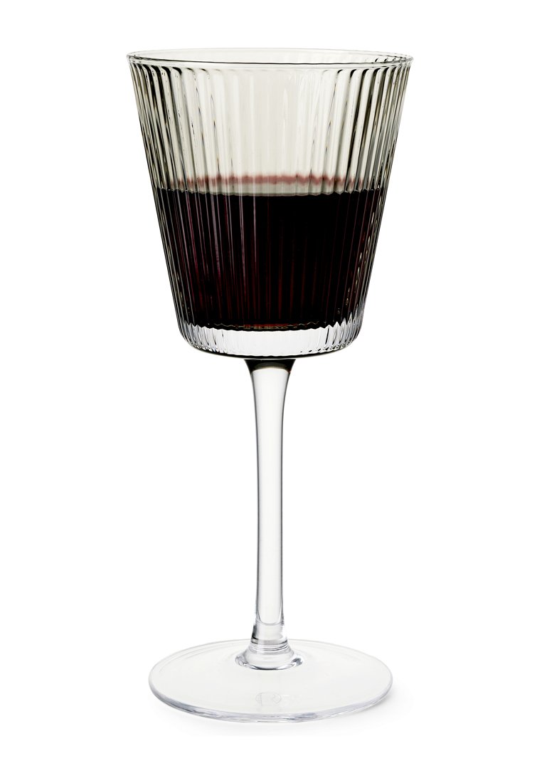 Klarglasweinglas mit gerippter Oberfläche, langem Stiel und runder Basis. Enthält eine dunkelrote Flüssigkeit, die die filigrane Texture des Glases präsentiert.