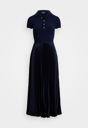 Karaliski zils plisēts kleita ar īsām piedurknēm polo stilā, ar apkakli un trīs pogām, kas pāriet plūstošā plisētā svārku daļā.