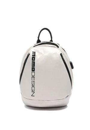 Sac à dos blanc arrondi avec texte vertical noir "Momo DESIGN", fermetures éclair noires sur les côtés et poignée noire sur le dessus.