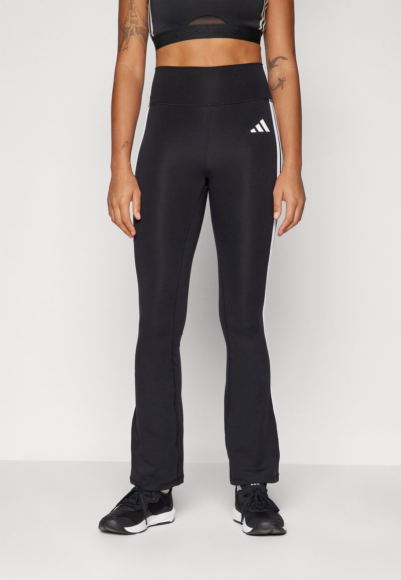 Pantaloni sportivi neri con un design svasato, dotati di strisce bianche sui lati e di un logo adidas sulla parte anteriore sinistra. Realizzati in tessuto elasticizzato.