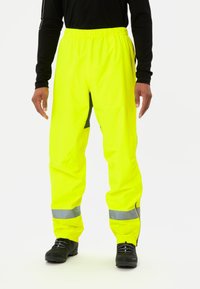 Pantaloni impermeabili giallo ad alta visibilità con vita elastica, strisce riflettenti e dettagli neri, progettati per la sicurezza in condizioni di scarsa illuminazione.