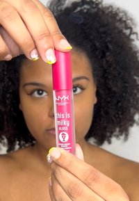 NYX Professional Makeup glansande läppprodukt i en genomskinlig tub med ett klart rosa lock. Etiketten säger "this is milky gloss" och "Mixed Berry Shake."