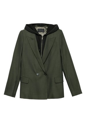 Groene op maat gemaakte blazer met gestructureerde schouders, twee voorkruimelzakken en een zwarte hoodie eronder. Glad van textuur met een knoopsluiting.