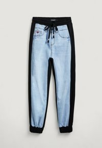 Joggers de denim azul claro con paneles laterales negros, cinturilla elástica y puños; cuenta con etiqueta de marca y cordón de contraste.