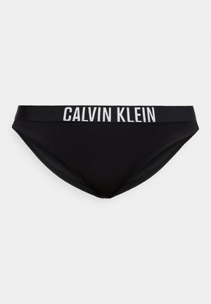 Zwarte slip in korte stijl met een brede tailleband waarop het witte CALVIN KLEIN-logo tekst gecentreerd aan de voorkant staat.