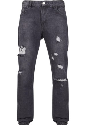 Dunkelgraue Jeans aus Denim mit mehreren beschädigten Löchern und ausgefransten Kanten; klassisches Fünf-Taschen-Design mit Knopfverschluss und Gürtelschlaufen.