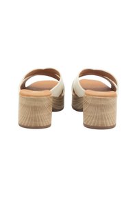 Sandalias deslizantes de color crema con correas curvadas, tacones de corcho y un patrón de vetas de madera texturizado en la superficie del tacón. Plantilla suave para mayor comodidad.