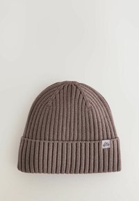 Braune gerippte Strickmütze mit umgeschlagenem Rand und einem kleinen Logo-Patch. Hergestellt aus weichem Material, mit vertikalen Streifen und einer abgerundeten Oberseite.