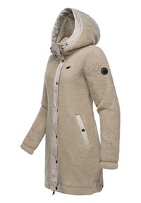 Beige faux fur coat with a hood, contrasting light beige lining, front zipper, and snap buttons; features side pockets and a logo patch.