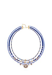 Collier de perles bleu à trois brins, avec des accents dorés et des charms décoratifs, y compris un motif central en forme d'œil et des formes de perles variées.