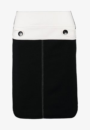 Biała bluzka z rękawami 3/4 i czarnymi akcentami, zestawiona z czarną spódnicą i czarnymi rajstopami. Trzyma czarną torebkę kopertową, prosta aplikacja guzikowa na spódnicy.