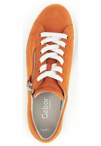 Baskets en suede orange avec lacets blancs, dotées d'une fermeture éclair sur le côté et d'une doublure intérieure douce. Semelle en caoutchouc plate et design à bout arrondi.