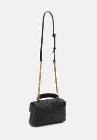Zwarte, gewatteerde leren handtas met een chevronpatroon, voorzien van een korte handgreep en een kettingband. Inclusief accenten in goudkleurige hardware.