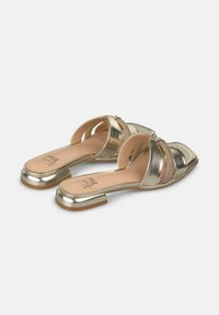 Gouden metallic instapsandalen met een lage blokhakken, meerdere overlappende banden en een textuurelement aan de voorkant. Platte zool.