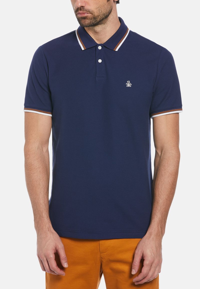 Polo bleu marine en coton, doté d'un col, de deux boutons et de rayures blanches et orange contrastantes sur le col et les manches.