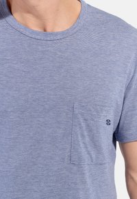 Blaue gestreifte Kurzarm-T-Shirt aus Baumwolle, mit Rundhalsausschnitt und einer Brusttasche mit kleinem Logo auf der Tasche.