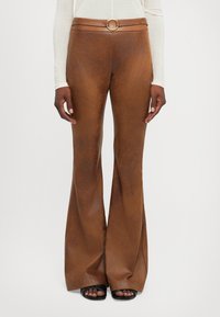 Brown faux leather flared pants with a smooth texture, featuring a high waistband and a gold circular buckle at the belt.