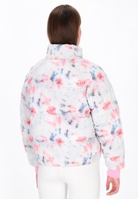 Padded jacket w kolorze tie-dye w odcieniach różu, niebieskiego i szarości. Wysoki kołnierz i ściągacze przy mankietach. Miękka, teksturowana tkanina z widocznymi szwami.