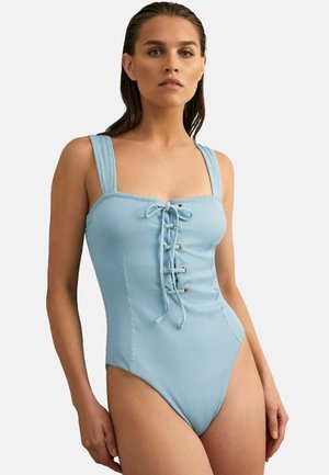 Una bañador de una sola pieza de color azul claro con relieve, que presenta un escote cuadrado, un frente con cordones y tirantes anchos, con aberturas de pierna de corte alto.