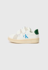 Vita sneakers med grå och gröna accenter, featuring kardborreband och en blå "CK"-logotyp. Platt beige gummisul. Slät textur.