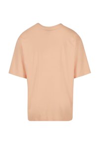 Pfirsichfarbendes Baumwoll-T-Shirt mit lockerer Passform, kurzen Ärmeln, Rundhalsausschnitt und glatter Textur, ohne sichtbare Grafiken oder Muster.