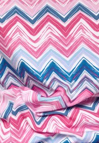 Baumwollstoff mit einem Zickzackmuster in Rosa, Hellblau und Dunkelblau, mit glatter Textur und subtilen Schattierungsvariationen.