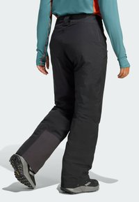 Čierne snehové nohavice so rovnom strihom, zosilnenými panelmi na členkoch a nastaviteľným pásom. Navrhnuté s dôrazom na funkčnosť a výkon v teréne.