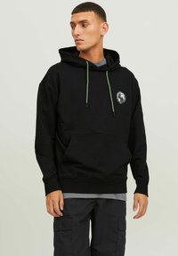 Hoodie noir avec poche avant, cordons de serrage verts et impression graphique sur la poitrine. Fabriqué en mélange de coton doux, il présente des poignets côtelés.